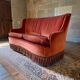 Vintage two-seater armchair in powder pink velvet with fringes.