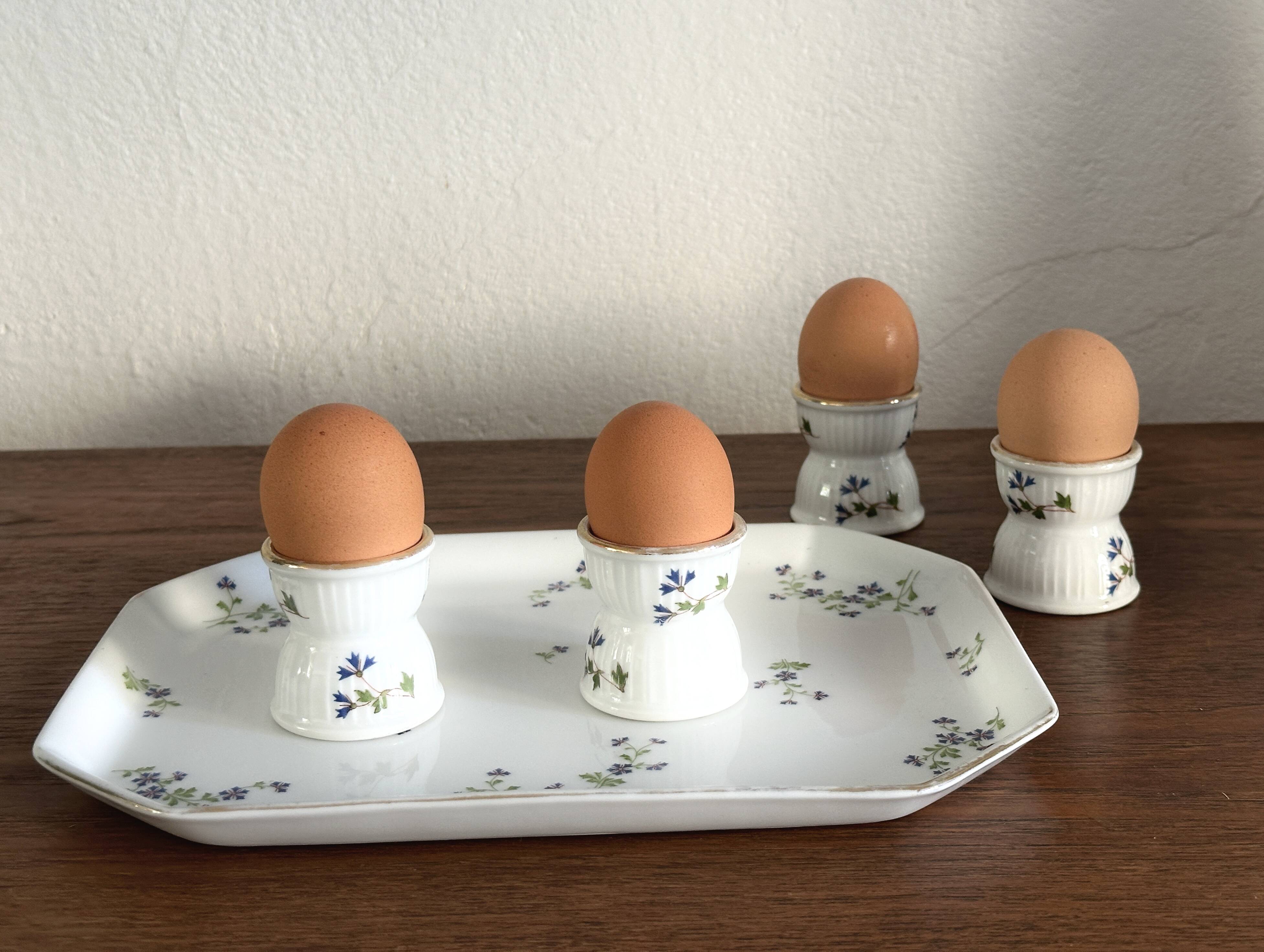 Egg cups on a Limoges porcelain tray by Bernardaud with a barbel decoration.