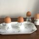 Egg cups on a Limoges porcelain tray by Bernardaud with a barbel decoration.