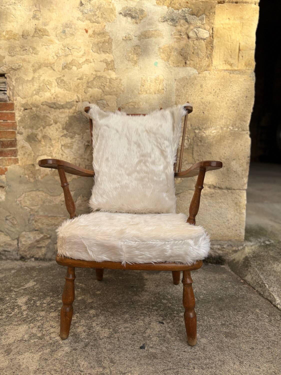 Scandinavian armchair in solid wood with beige fur cushion