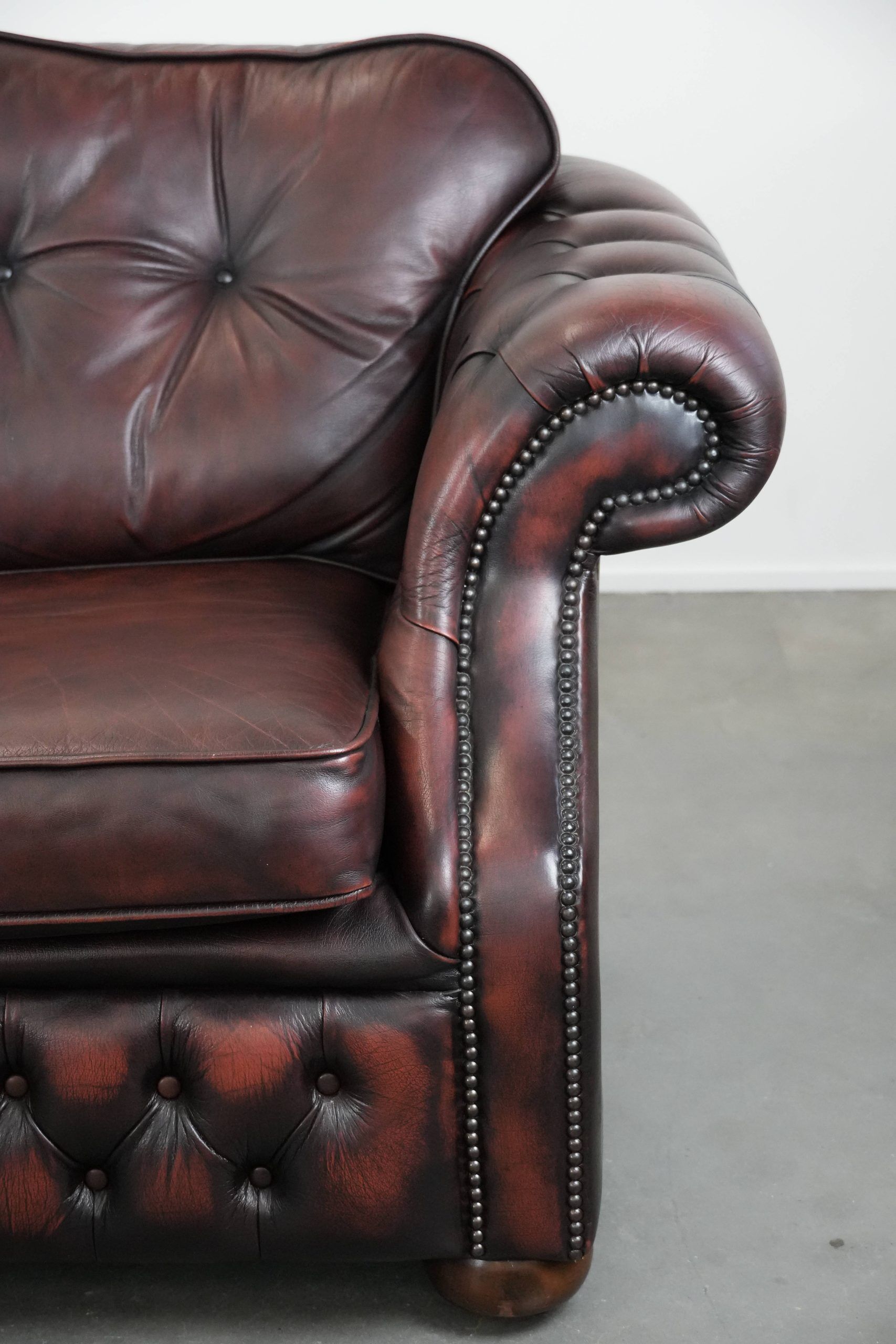Red 2.5-seater Chesterfield sofa on wheels in English style