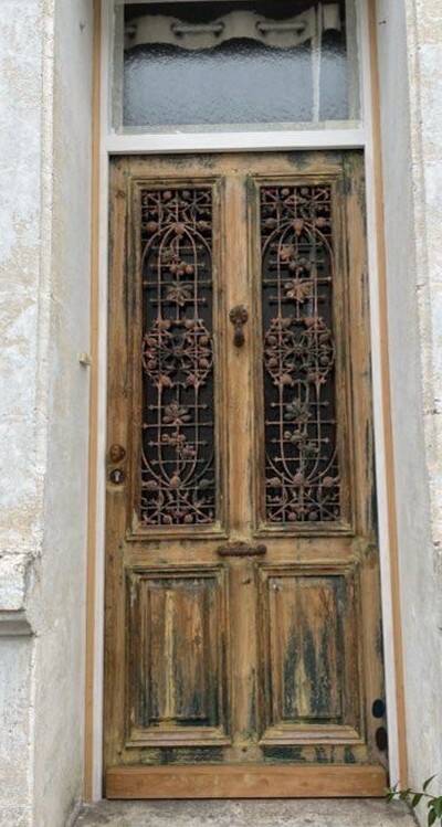 Front door of a house or building in the city centre, with a dolphin door knocker and frame + transom.