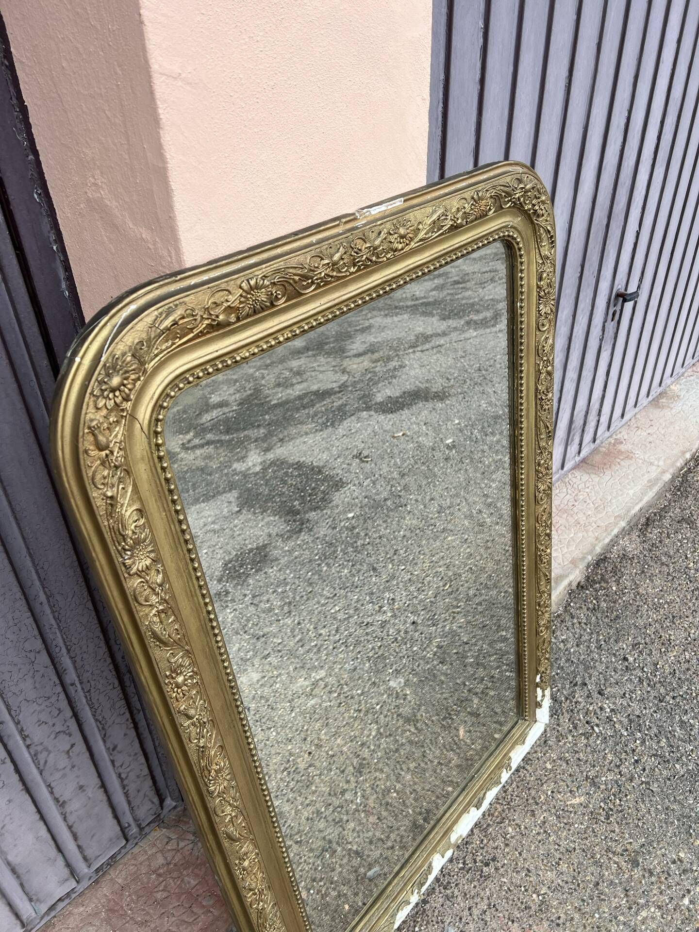 Large Louis Philippe mirror in carved gilded wood with mercury glass.