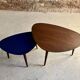 A pair of tripod and nesting coffee tables in walnut and midnight blue.