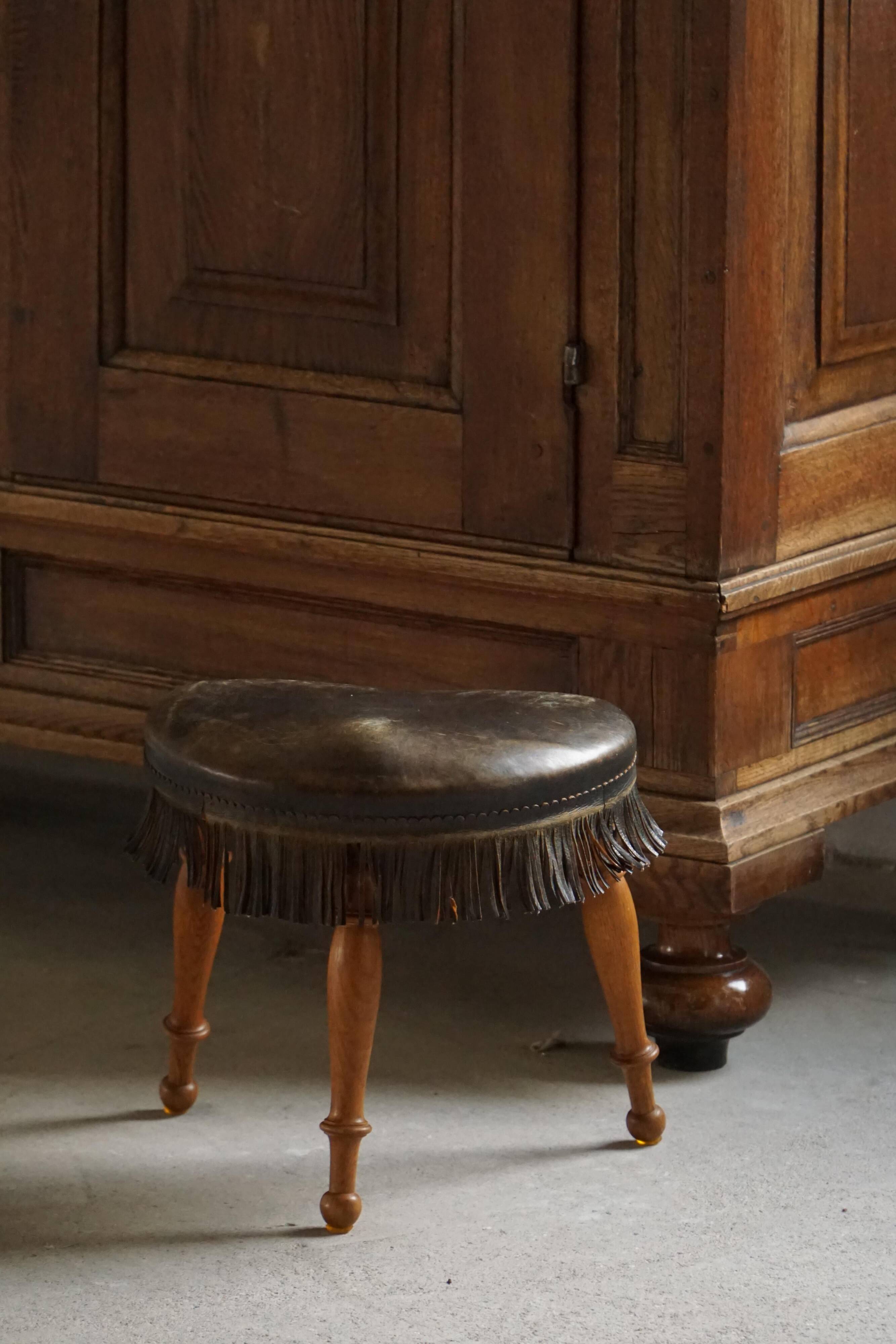 Danish oak tripod stool from the early 20th century with leather fringe, 1930s.