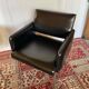 Pair of vintage armchairs in black faux leather and chrome metal.
