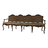 Grande banquette Louis XV en bois naturel mouluré et sculpté, France XVIIIème siècle