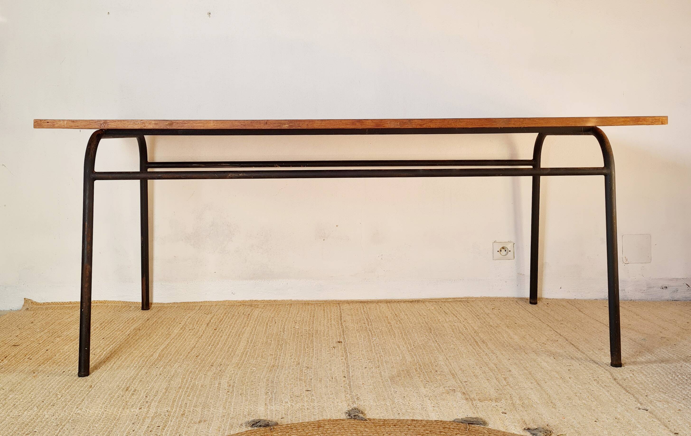 Table with tubular metal legs and wooden top.