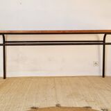 Table with tubular metal legs and wooden top.