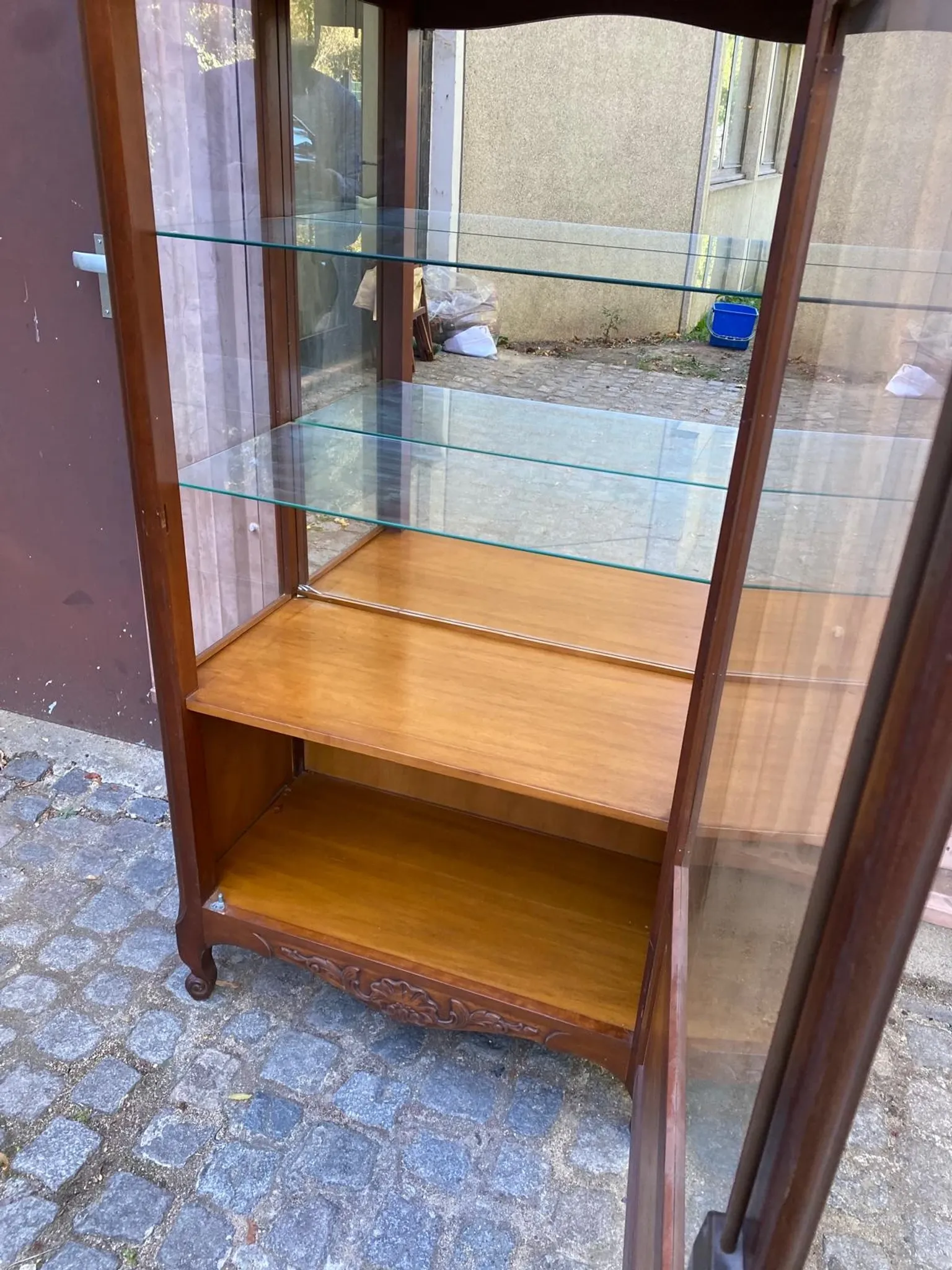 Louis XV style display cabinet in cherry wood with a mirrored back and glass shelves.