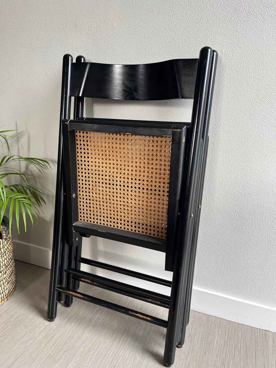 Vintage folding chairs in black wood and cane.