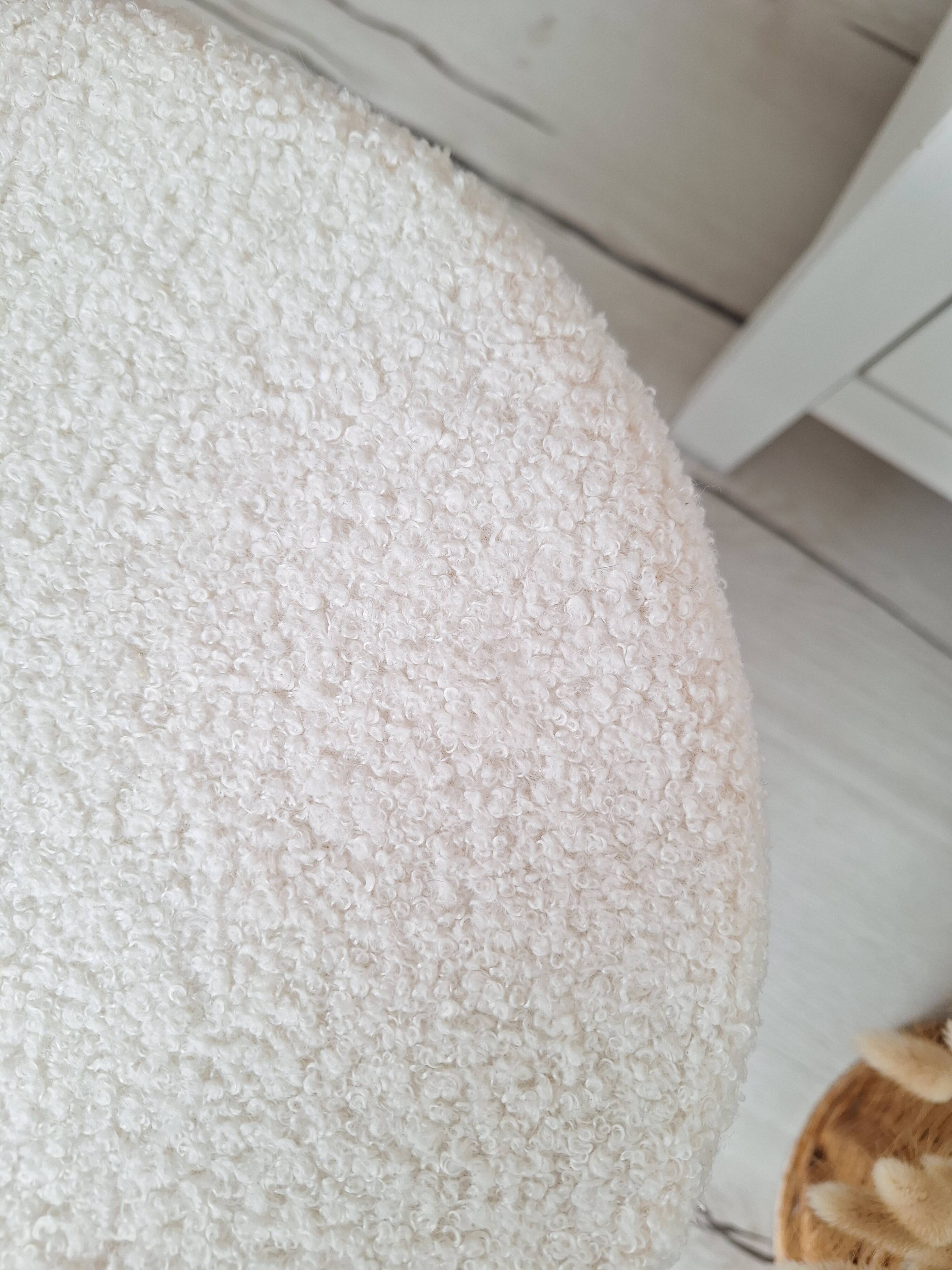 Black iron stool/pouf with its boucle fabric cushion.