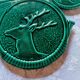 A trivet and two bottle holders in green Vallauris majolica.