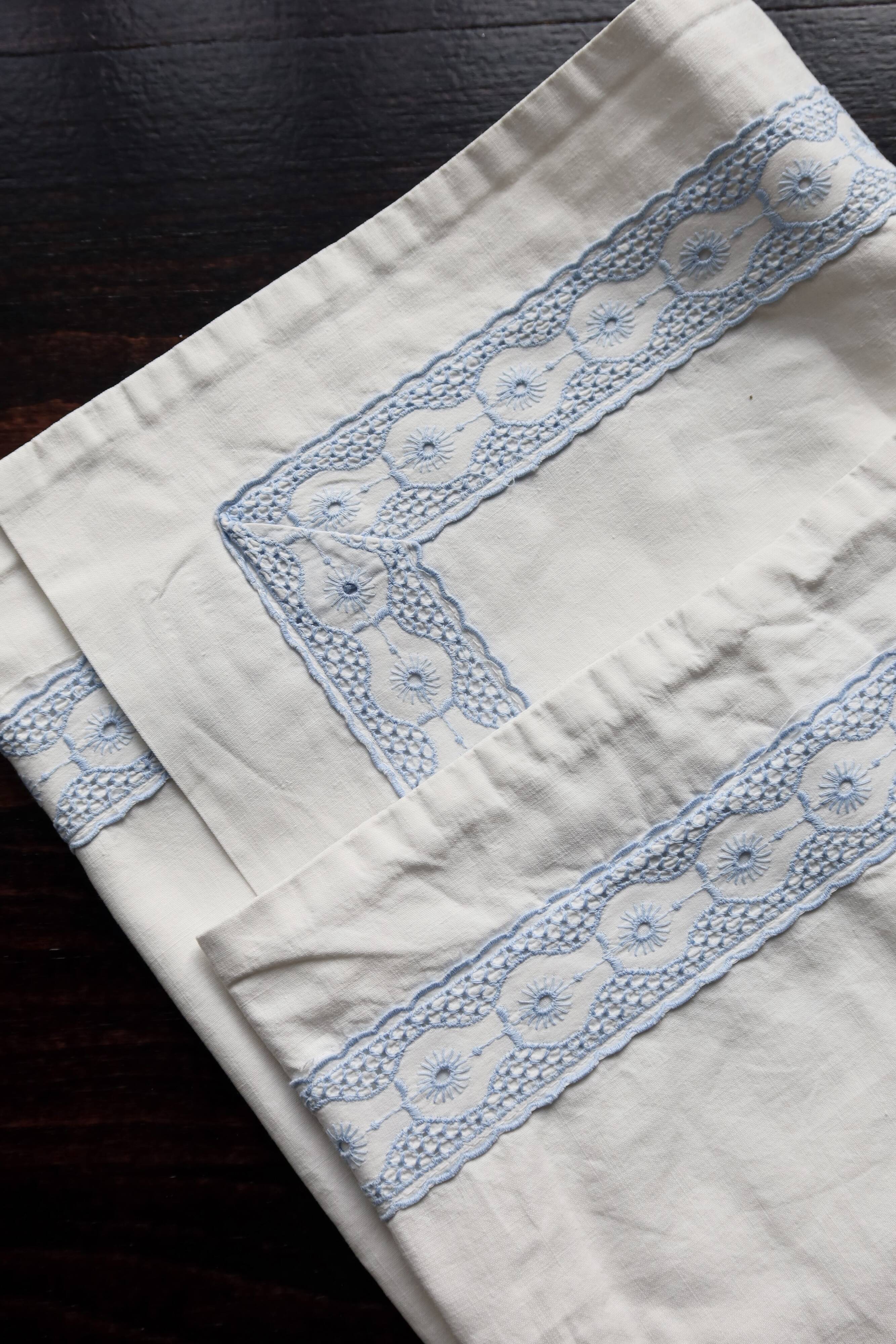 Vintage embroidered pillowcase with light blue thread.