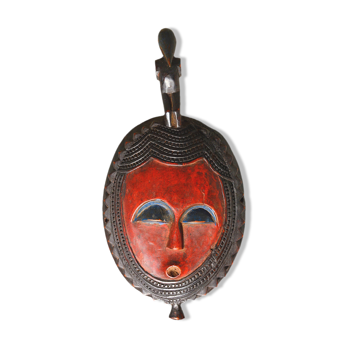 African wooden mask, face topped with a bird.