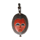African wooden mask, face topped with a bird.