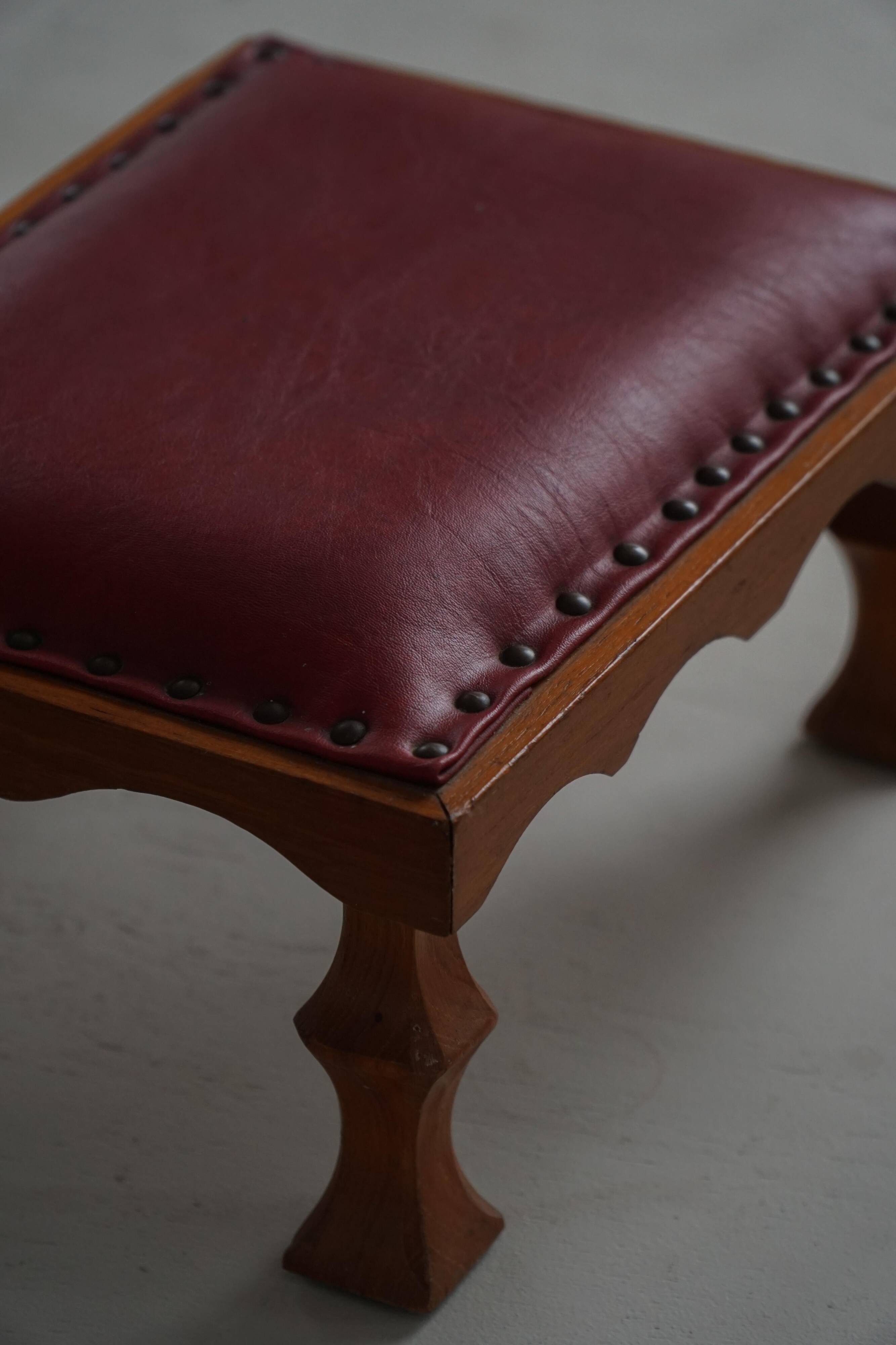 Danish sculpted oak stool from the mid-20th century with a red leather seat, 1950s.
