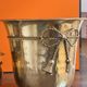 Pair of brass plant pots, decorated with cord and tassels.