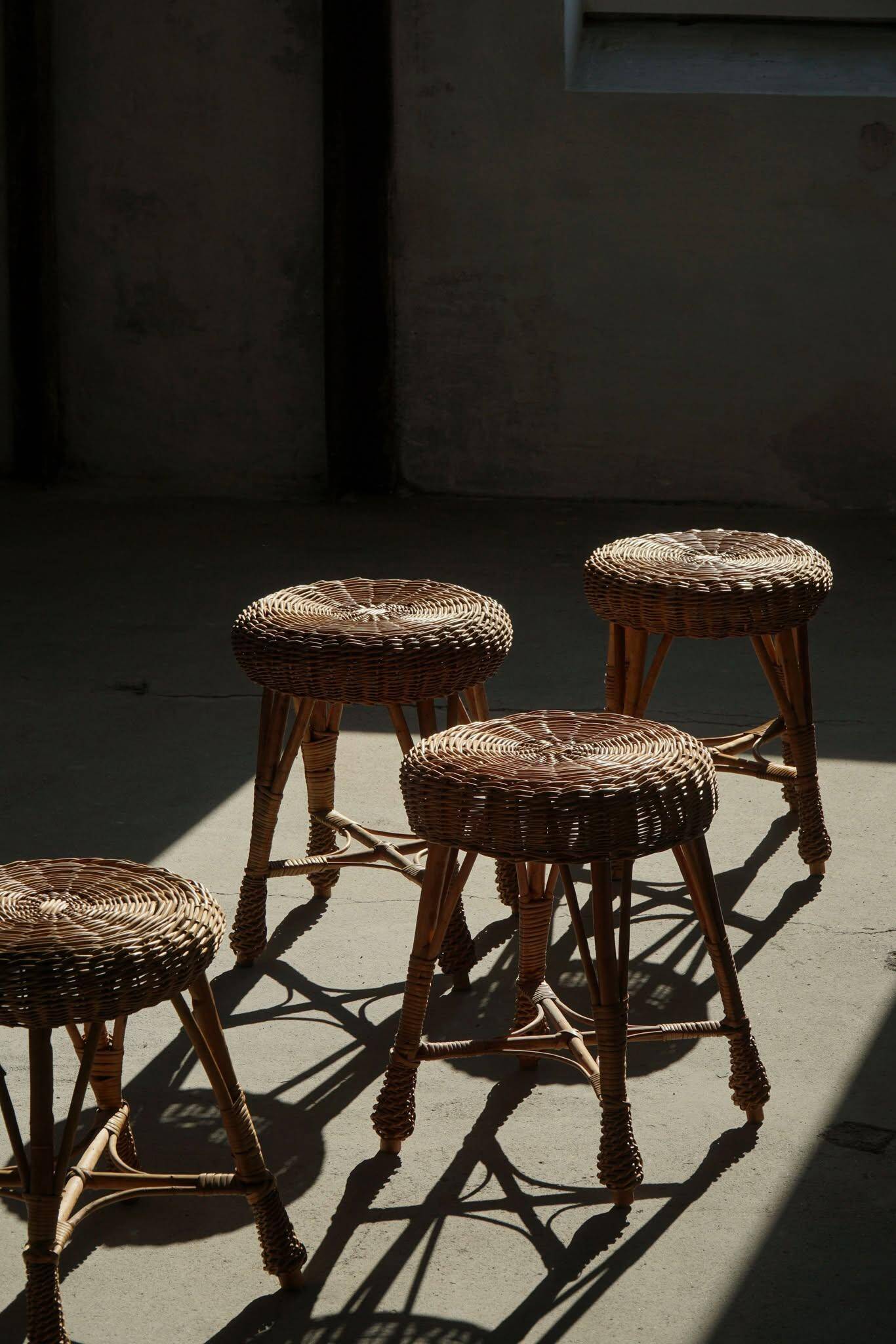 A set of 4 vintage Scandinavian rattan stools, in the style of Tony Paul, from the 1960s.
