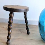 Small wooden tripod stool with turned legs, country style.