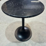 Round marble table with a black metal tulip base.