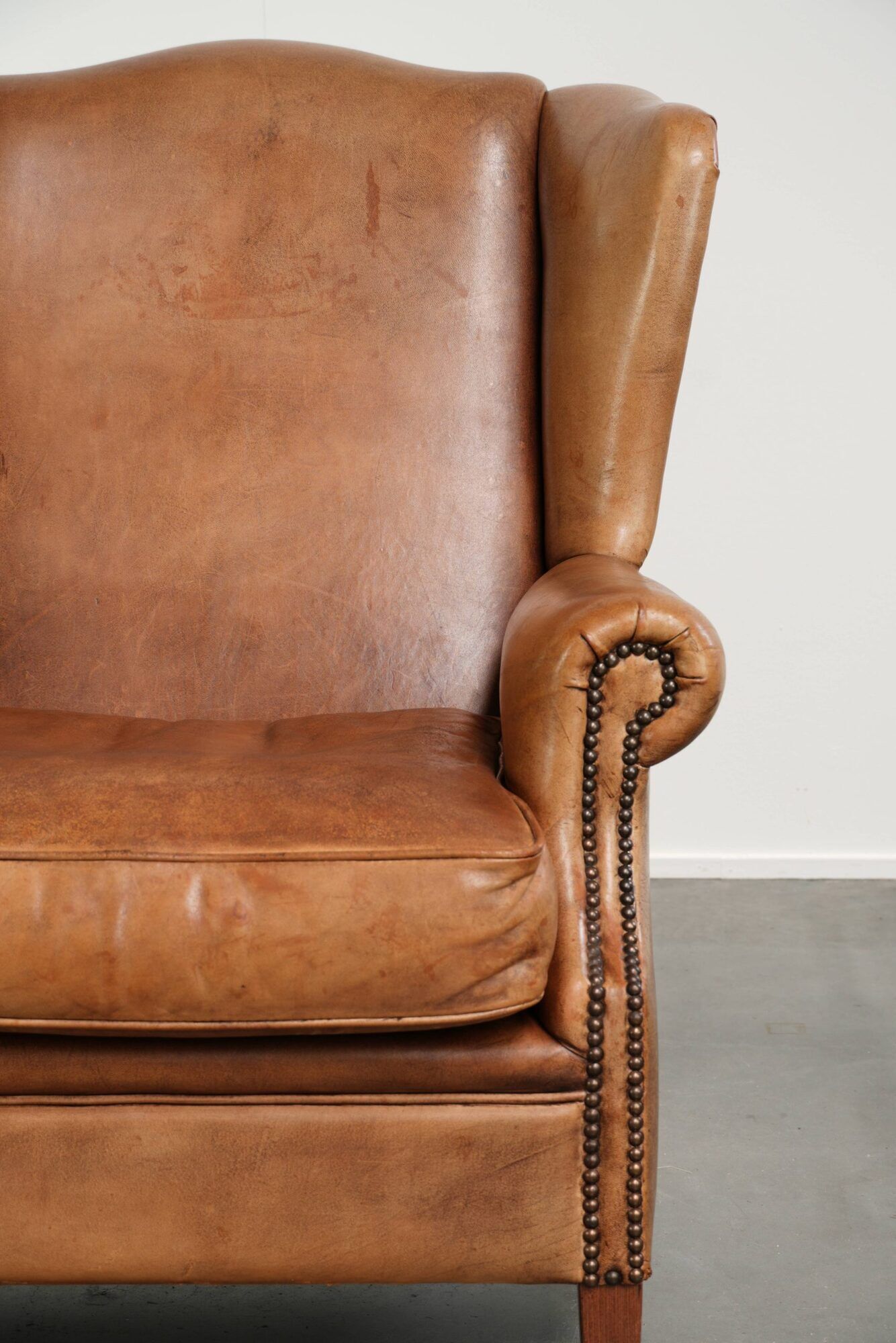 Sheepskin wingback armchair in a light cognac colour in English style
