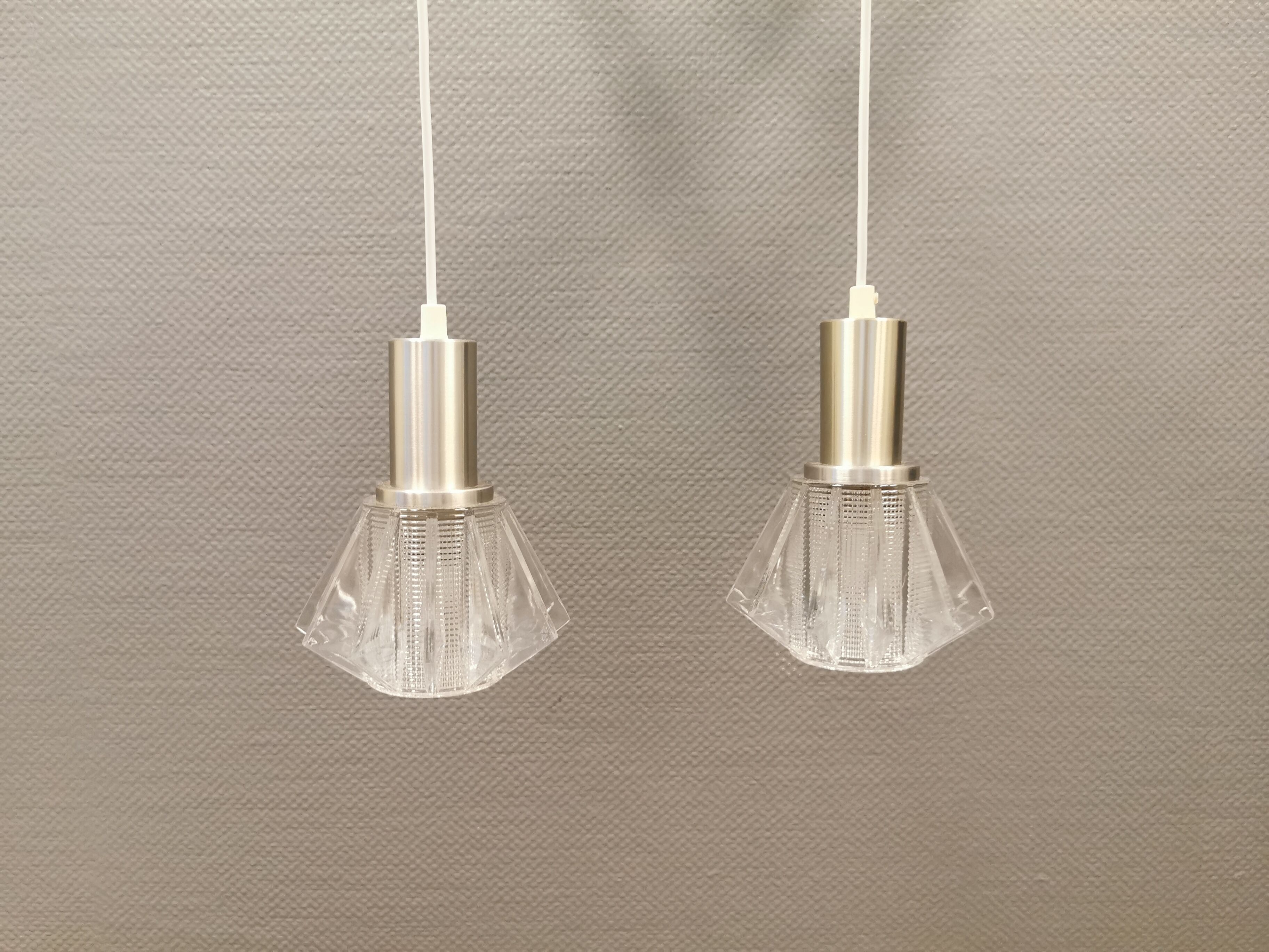 A set of smaller hanging lamps, in hard pressed glass, with metal top
