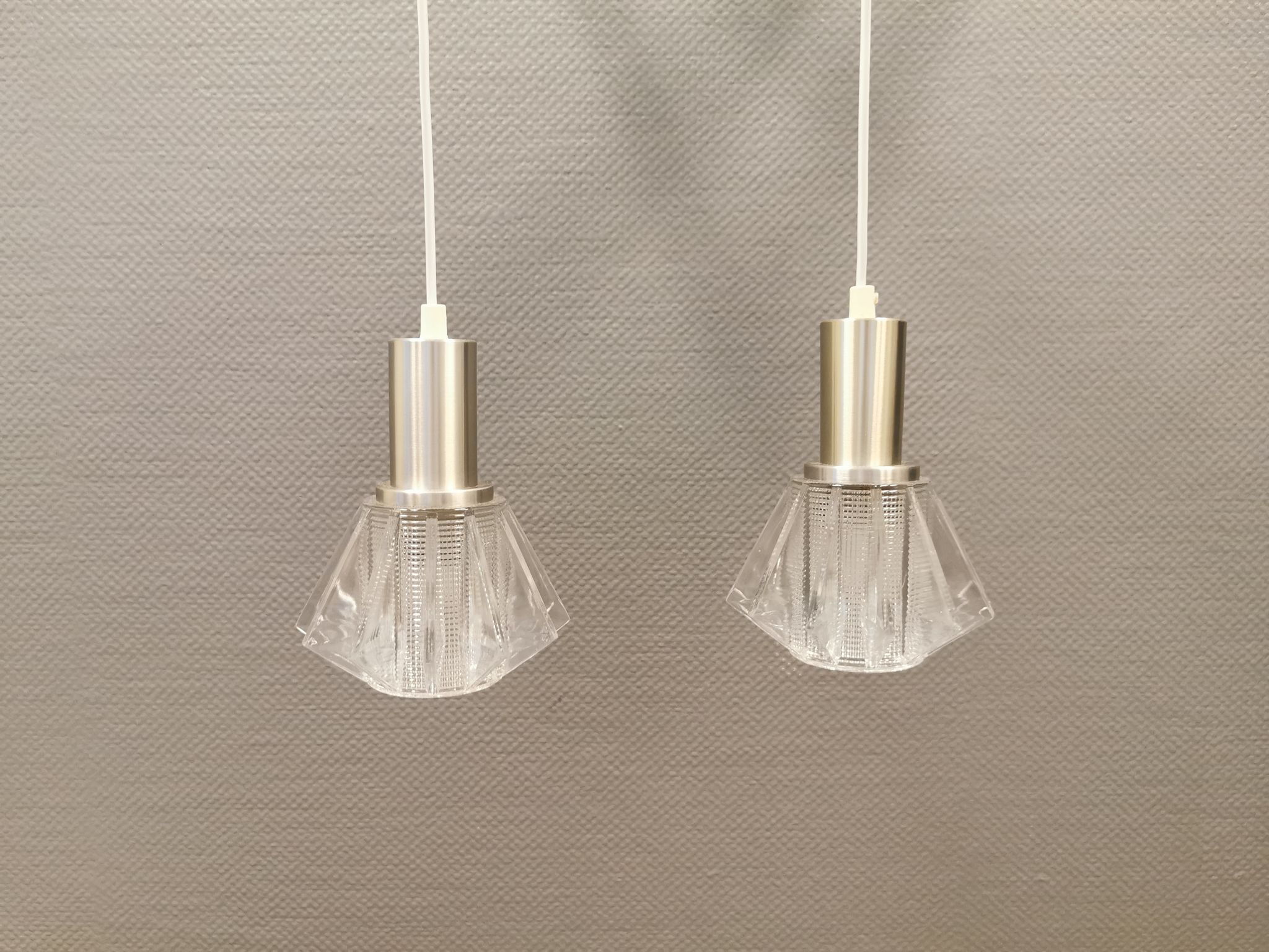 A set of smaller hanging lamps, in hard pressed glass, with metal top