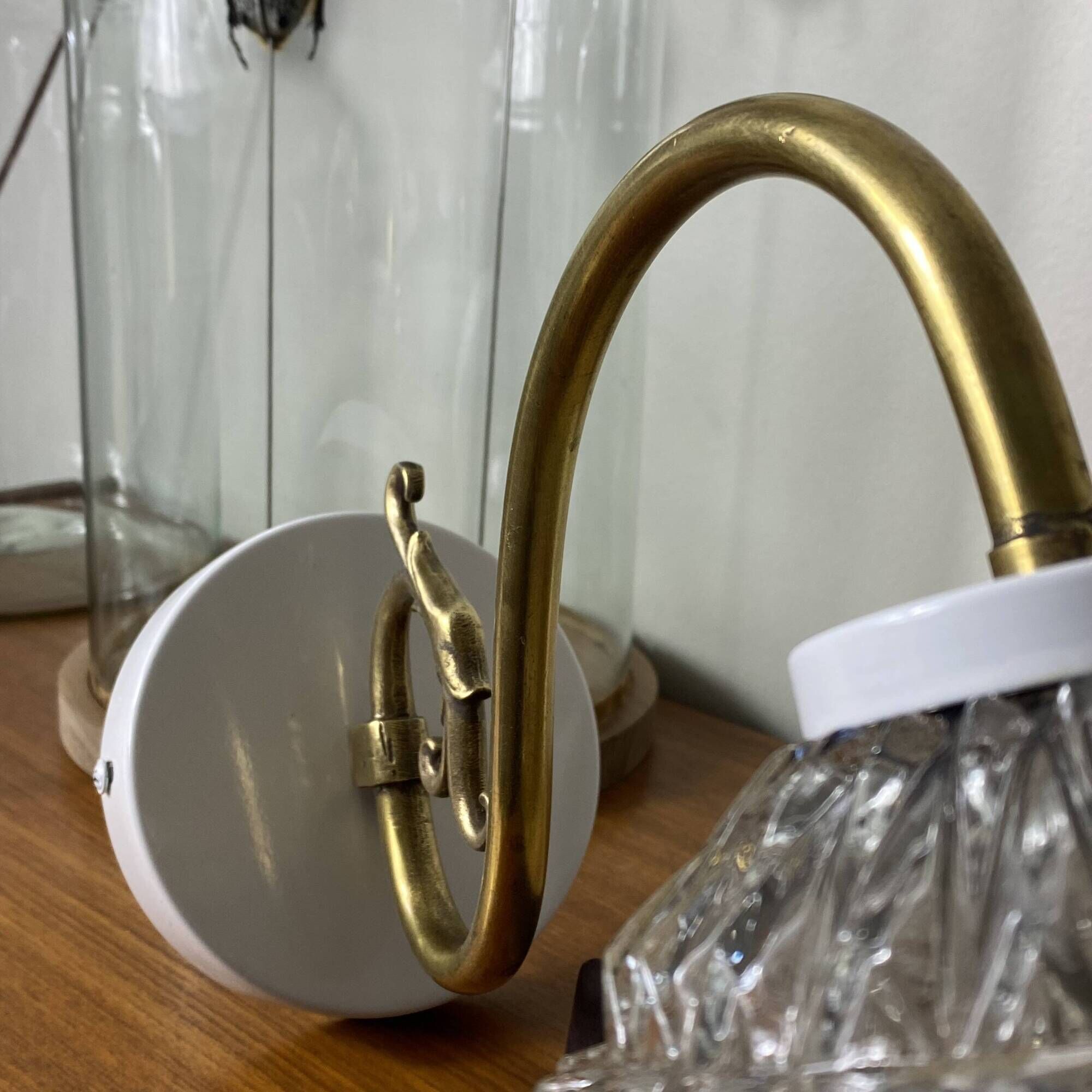 Large pair of brass swan neck wall lights with transparent glass globes.