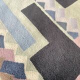 Hand-knotted wool rug by Tisca with a geometric pattern, signed "ILES", France, 1990s.