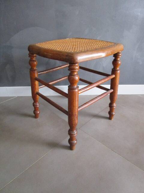 Antique wooden stool with cane seat.
