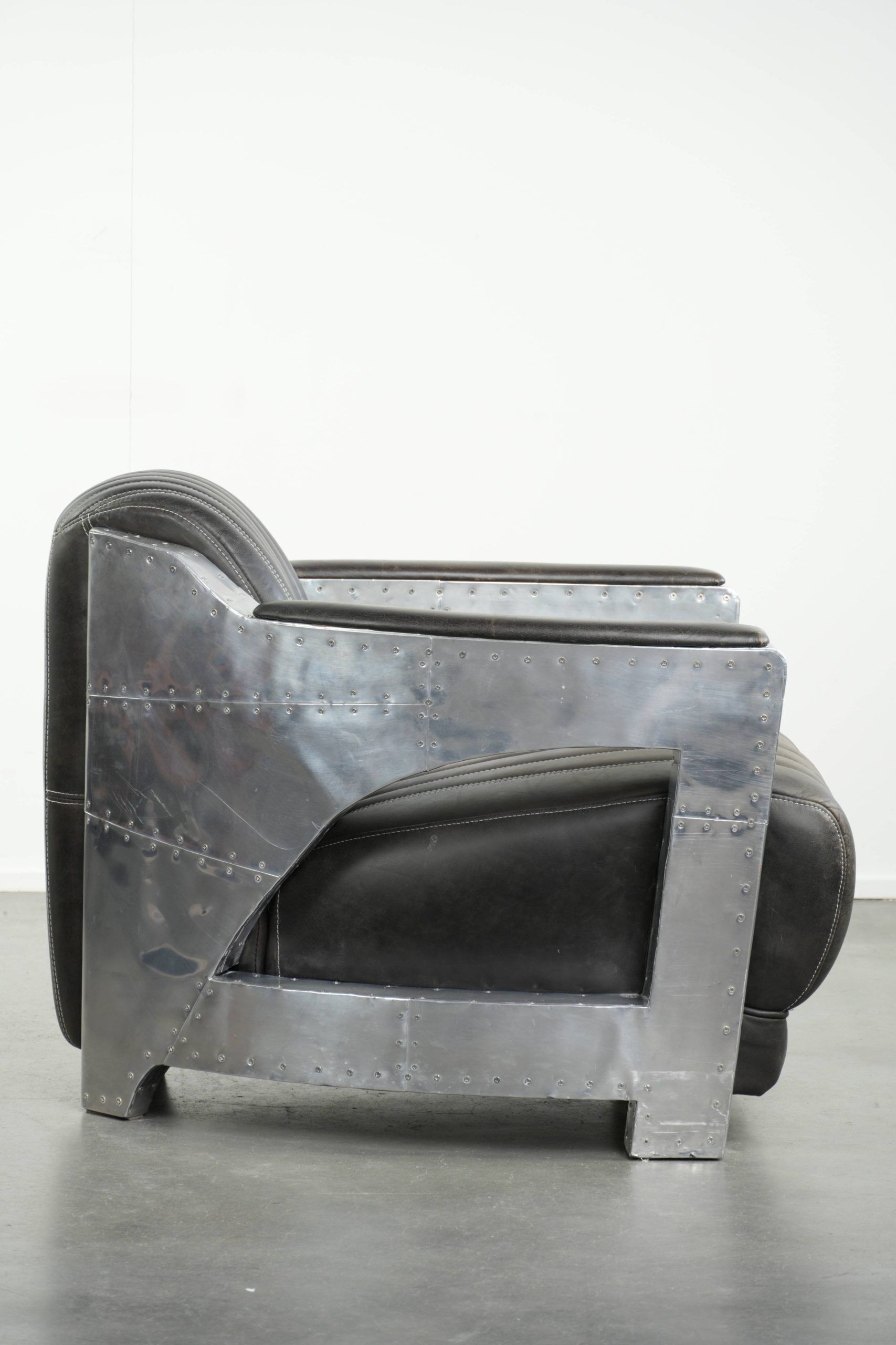 Cow leather aviator design armchair finished with aluminium and rivets