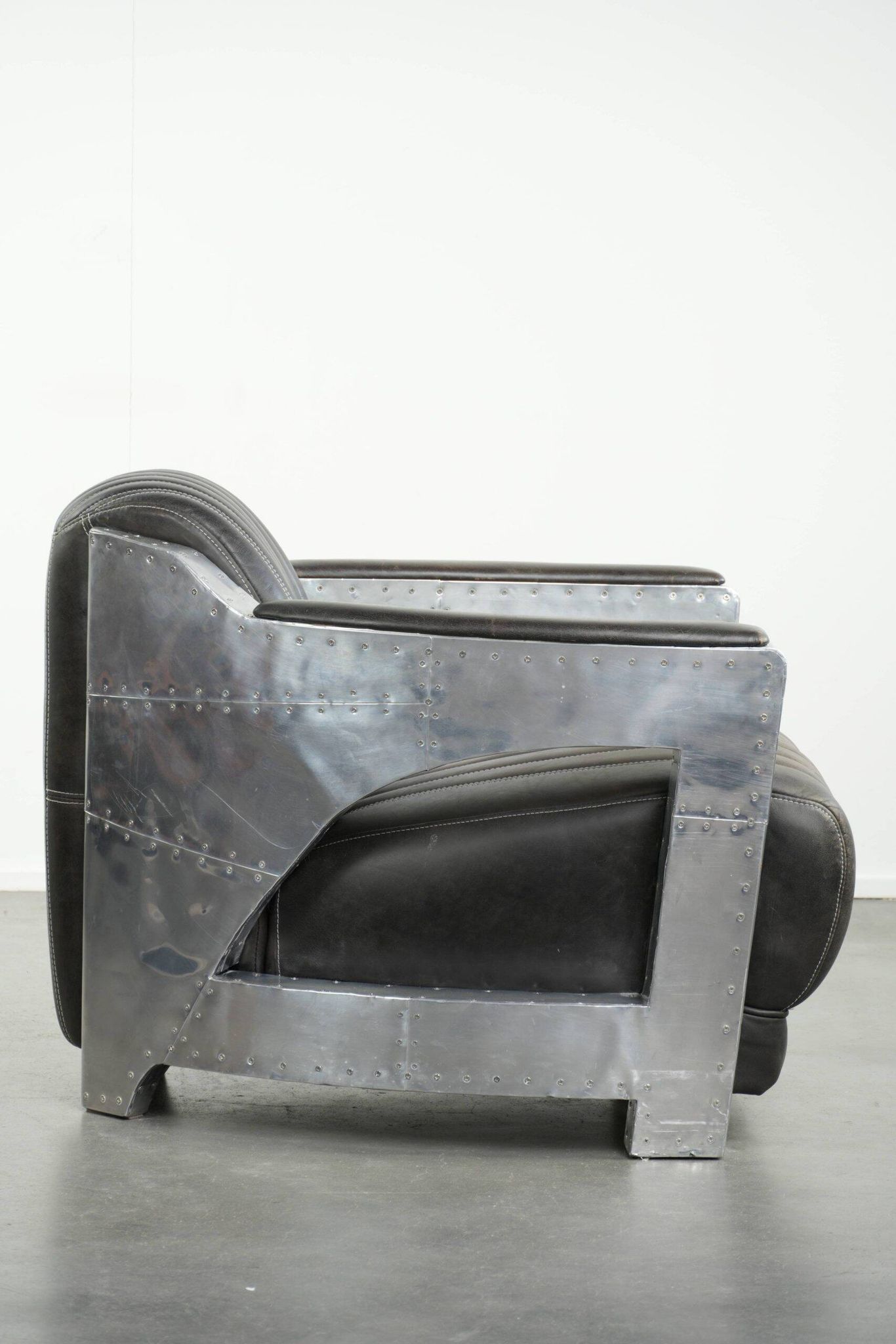 Cow leather aviator design armchair finished with aluminium and rivets