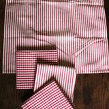 A set of 4 red striped and checkered napkins.