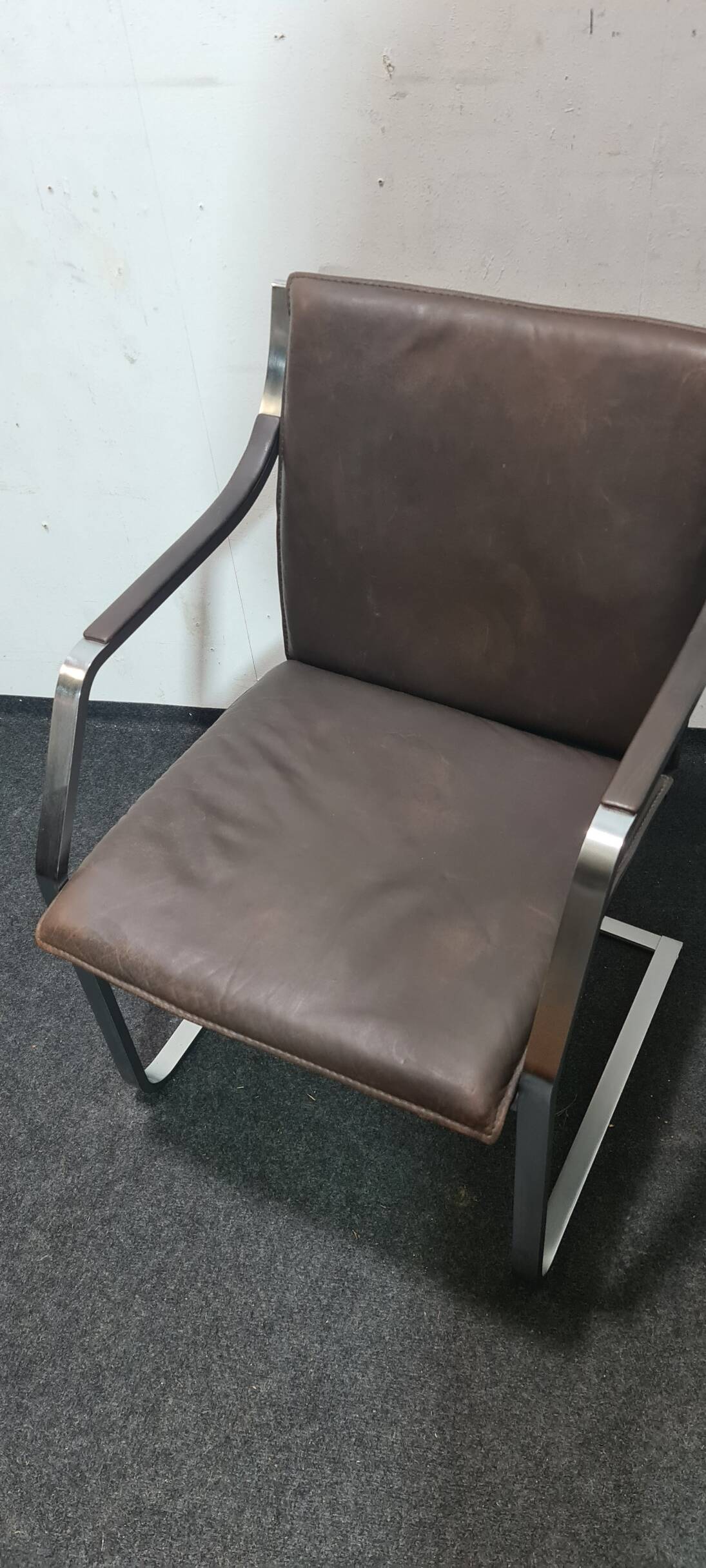 One of two vintage Leather and metal arm chairs.