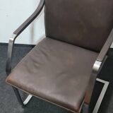 One of two vintage Leather and metal arm chairs.
