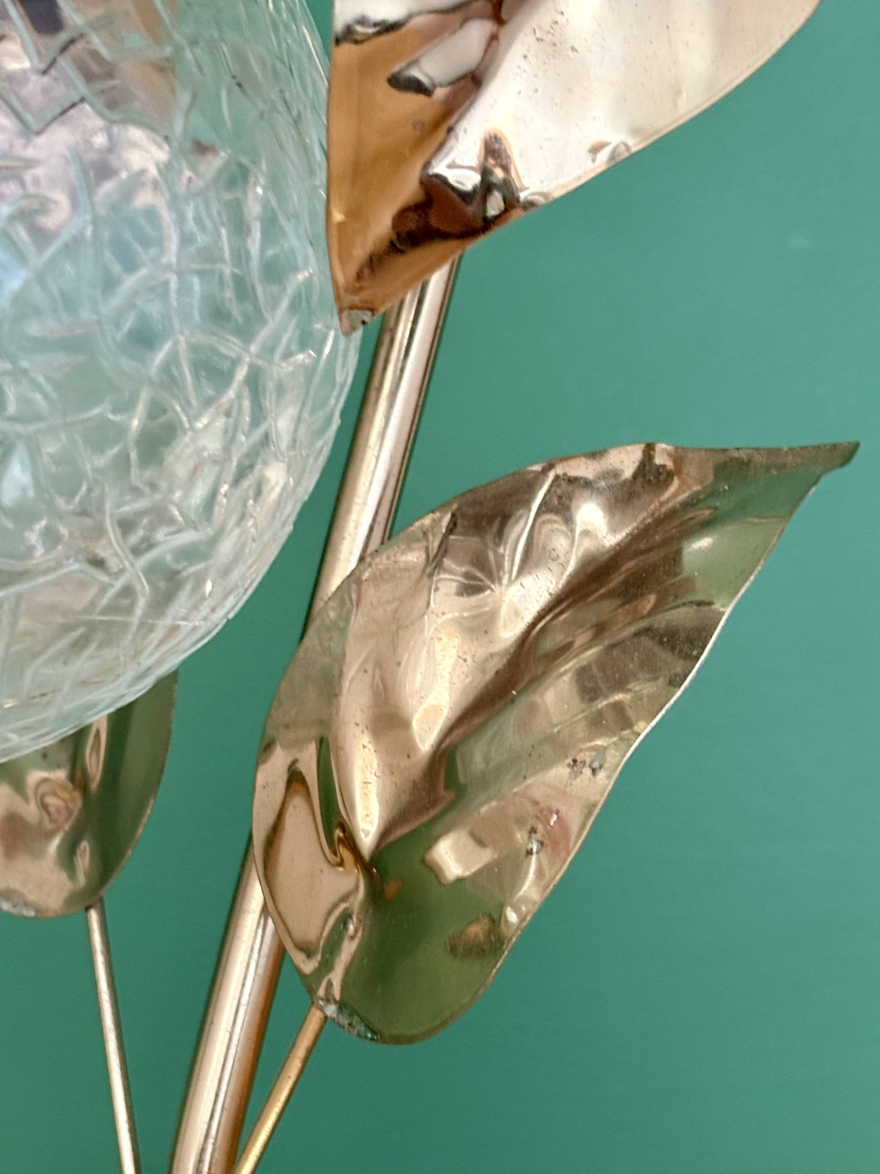 Vintage lamp with brass leaf design and transparent glass globe.