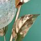 Vintage lamp with brass leaf design and transparent glass globe.