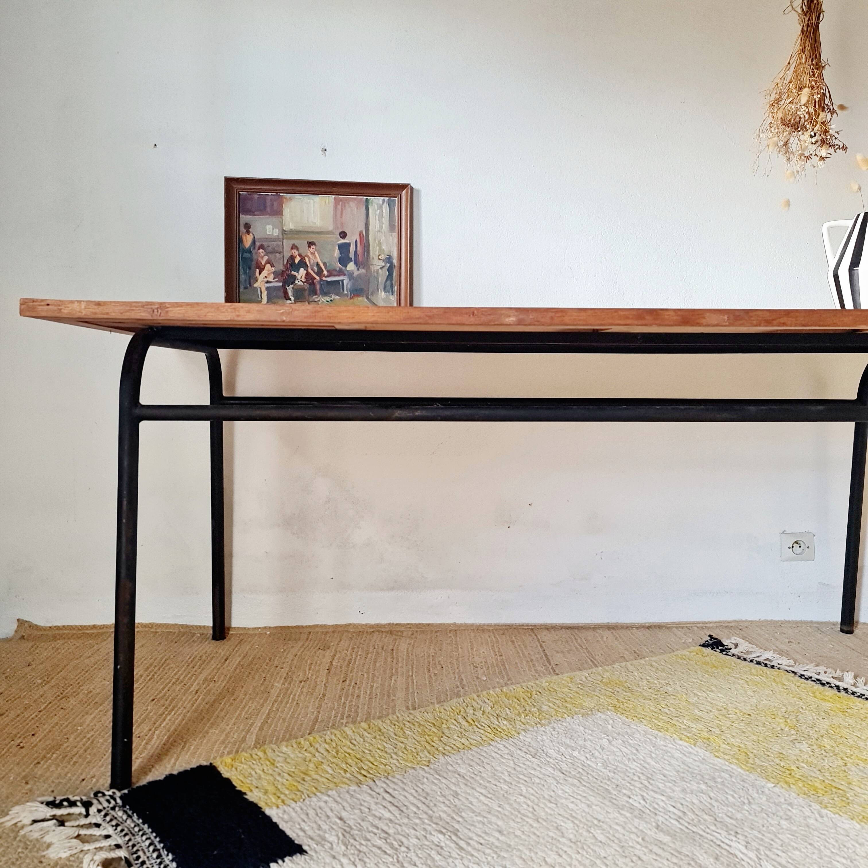 Table with tubular metal legs and wooden top.