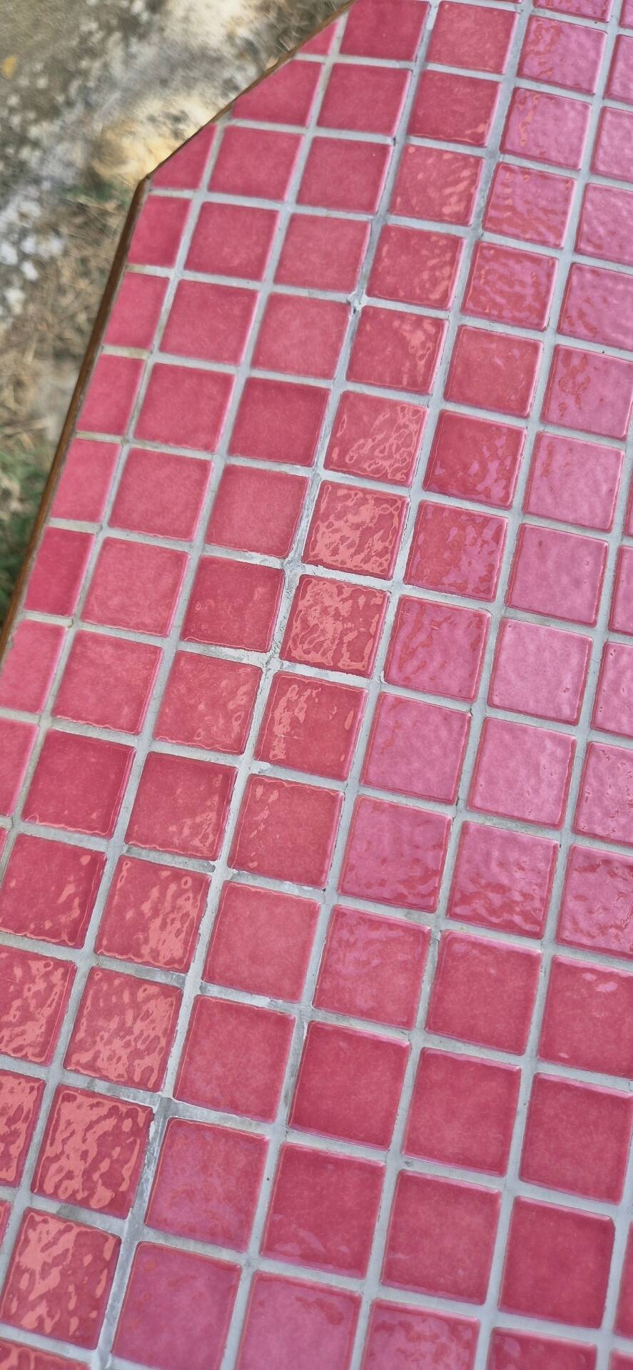 Small Scandinavian side table with wood and pink tiles, with tapered legs.