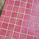 Small Scandinavian side table with wood and pink tiles, with tapered legs.