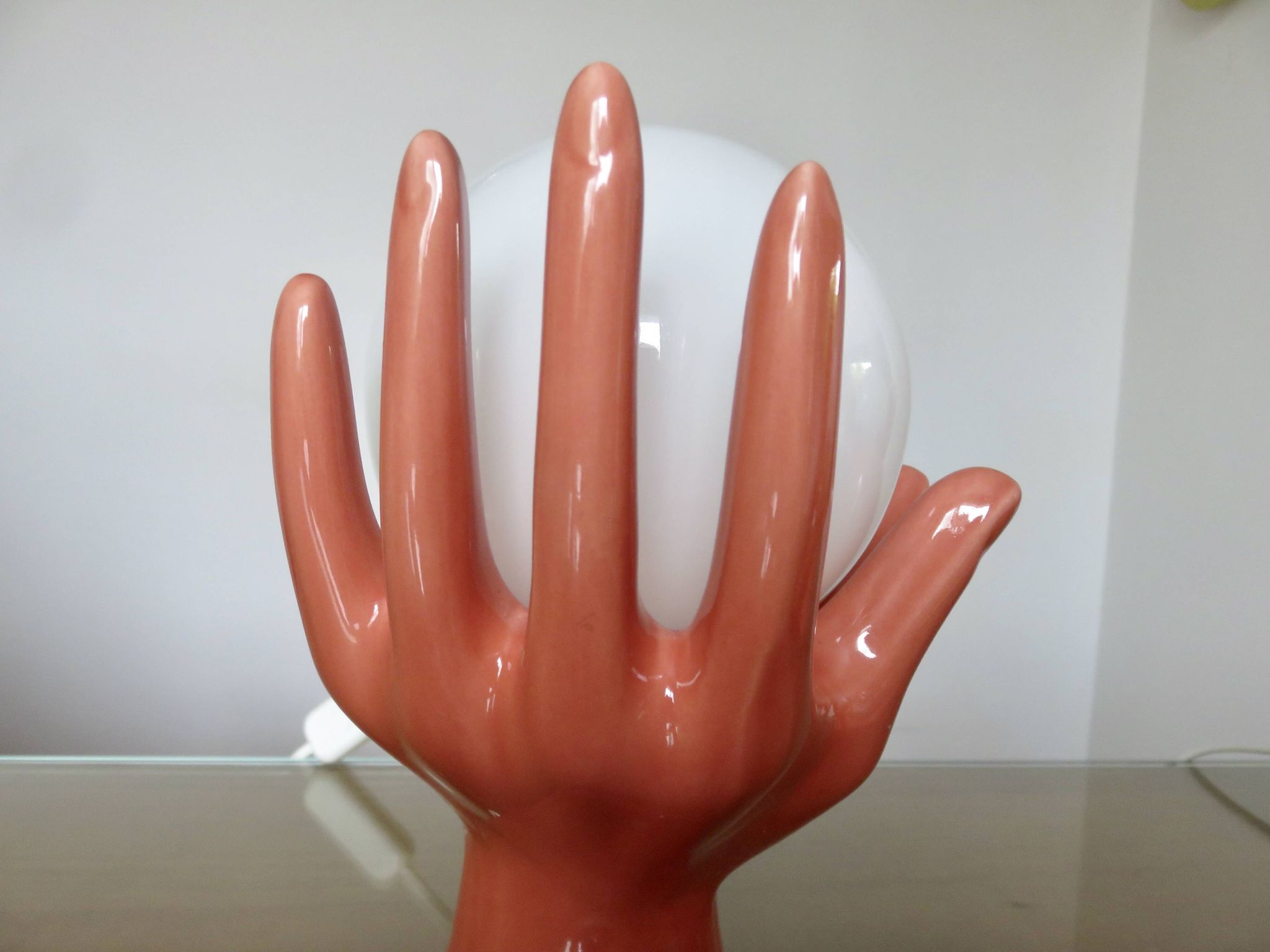 Pair of salmon-colored ceramic "hand" lamps with opaline globe, 80