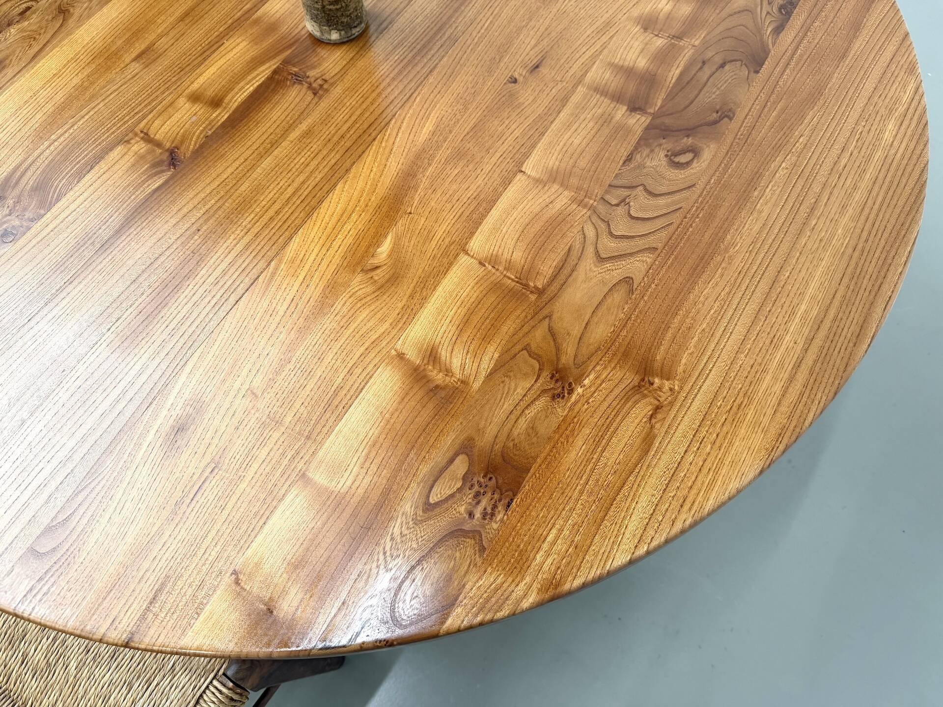 Modernist round table in solid elm, crossed legs.