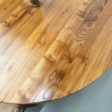 Modernist round table in solid elm, crossed legs.