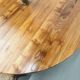Modernist round table in solid elm, crossed legs.