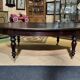 Large English library table in dark walnut with a leather top.