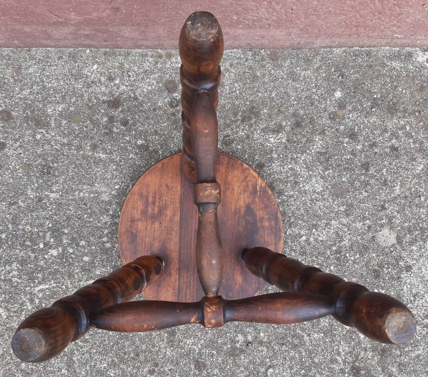 Low wooden tripod stool.