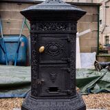 Black cast iron wood burning stove with solid brass handle.