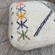 Berber floor pouf: Handwoven Moroccan wool cushion.