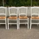 Set of 4 rustic white wooden chairs with straw seats.